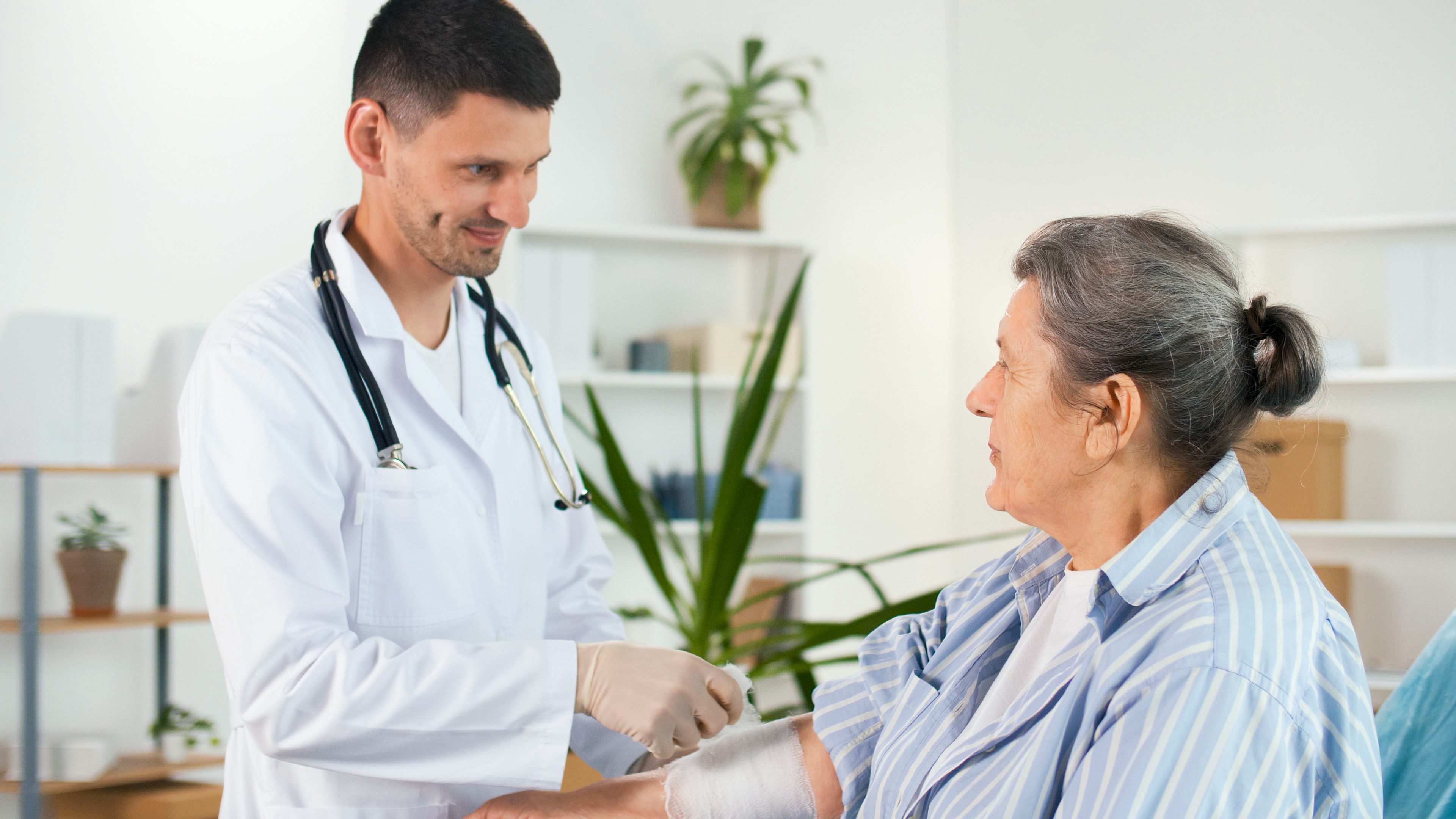 Médecin appliquant un bandage au bas d'une patiente