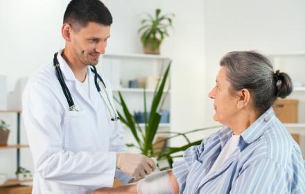 Médecin appliquant un bandage au bas d'une patiente